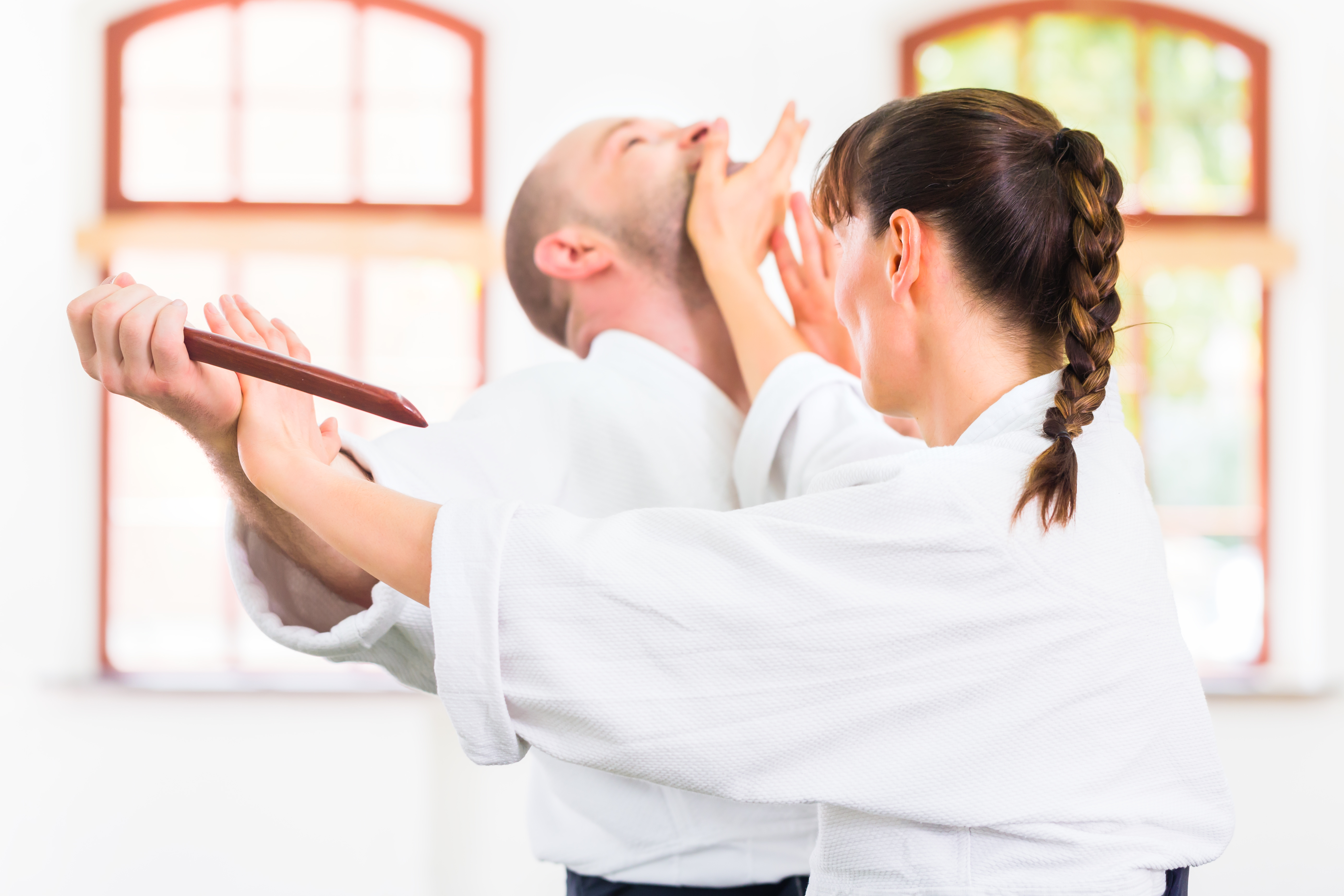 a woman practicing self defense at an aikido academy